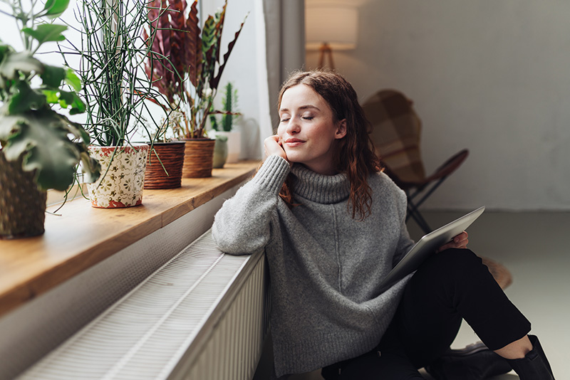 Femme assise devant un radiateur